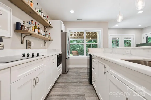 a kitchen with stainless steel appliances a dining table chairs stove refrigerator and cabinets