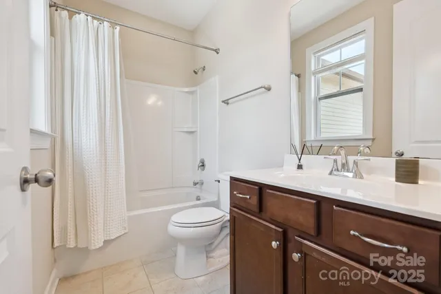 an empty room with windows and chandelier fan