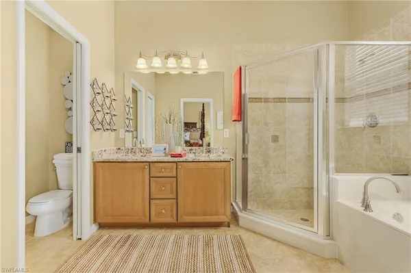 a bathroom with a granite countertop sink and a bathtub
