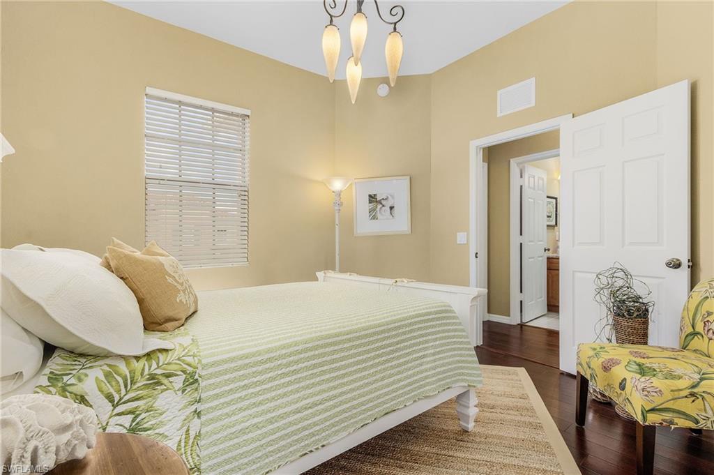 9803 Bodego Way, Unit 104 Fort Myers, FL 33908 - Photo 22 of 31 a bedroom with a bed and wooden floor