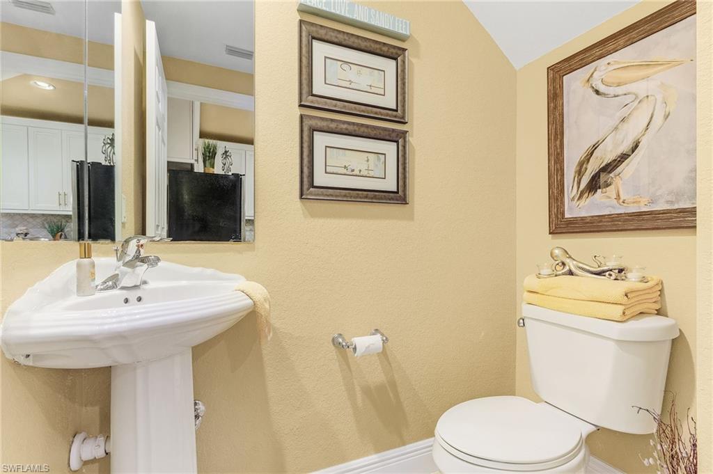 9803 Bodego Way, Unit 104 Fort Myers, FL 33908 - Photo 25 of 31 a bathroom with a sink and mirror with toilet