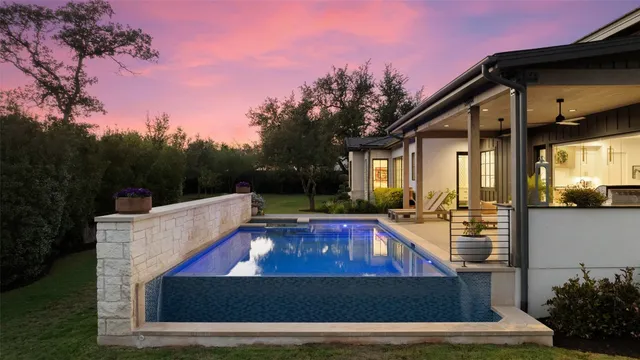 a view of a house with pool and sitting area