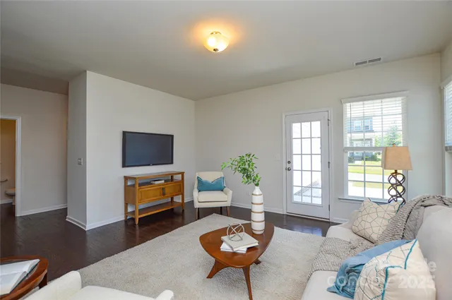 a living room with furniture a flat screen tv and a window
