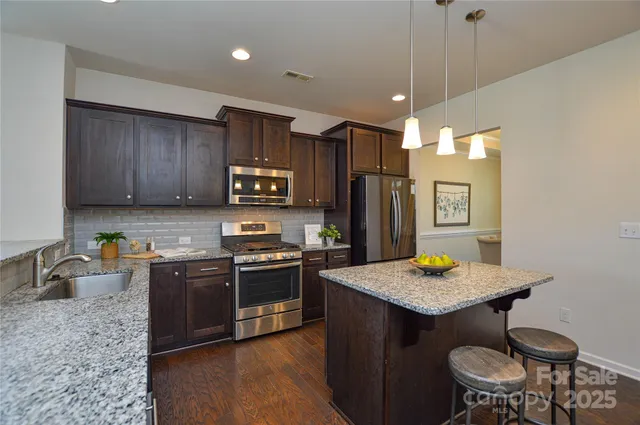 a kitchen with granite countertop wooden cabinets and stainless steel appliances