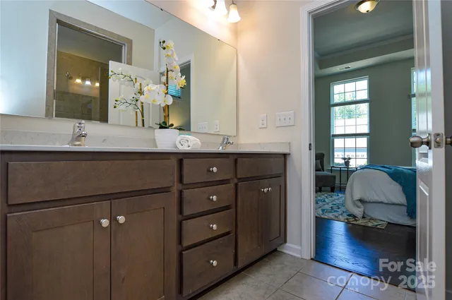 a en suite bathroom with a sink double vanity granite and a mirror