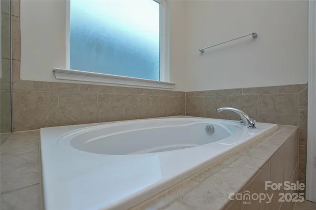 a bath tub sitting in a bathroom next to a white sink