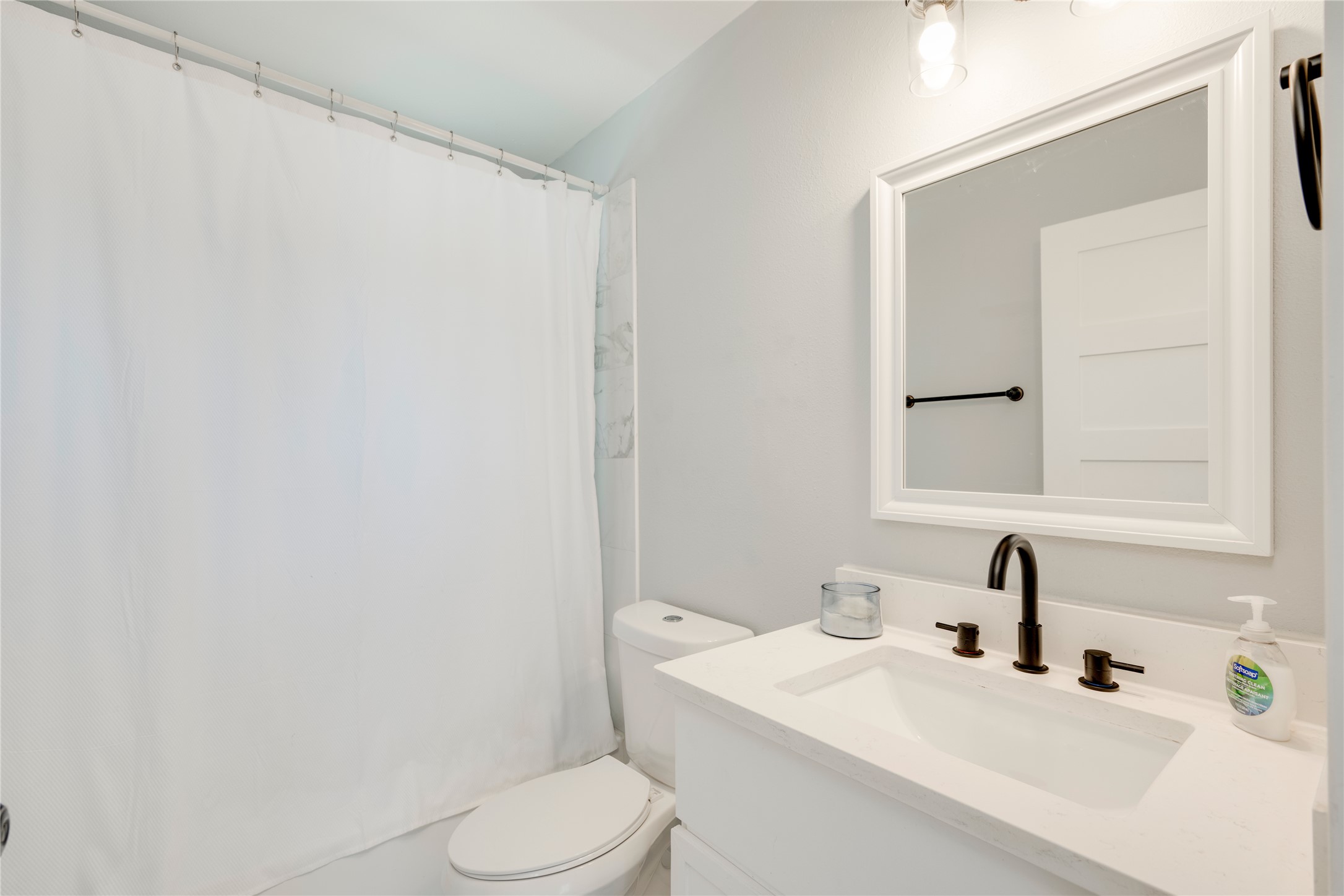 1400 Marcus Place, Unit B Austin, TX 78721 - Photo 16 of 39 A well-lit bathroom features a vanity with a sleek sink and modern dark bronze fixtures.