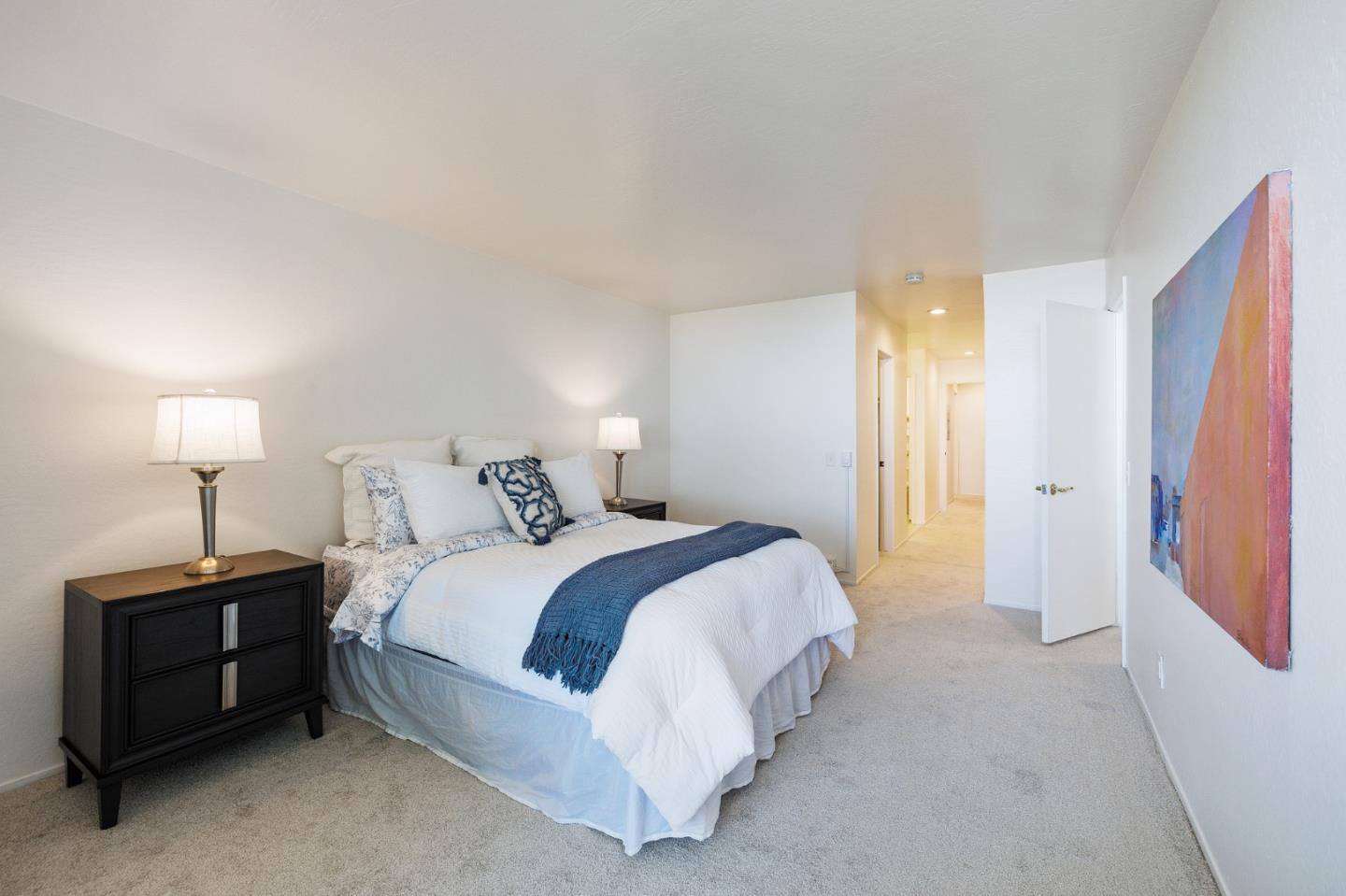 360 Vallejo Drive, Unit 113 Millbrae, CA 94030 - Photo 25 of 34 a spacious bedroom with a bed and a lamp