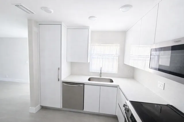 a view of an empty room with a kitchen