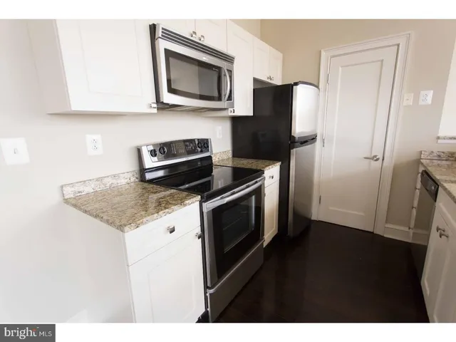 a kitchen with stainless steel appliances granite countertop a refrigerator microwave and sink