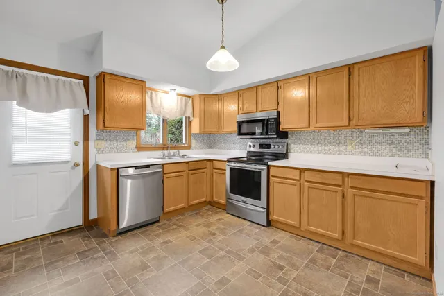 a kitchen with stainless steel appliances granite countertop a stove a sink and a refrigerator