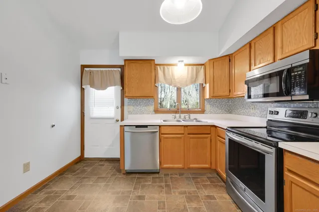 a kitchen with stainless steel appliances granite countertop a stove a sink and a microwave