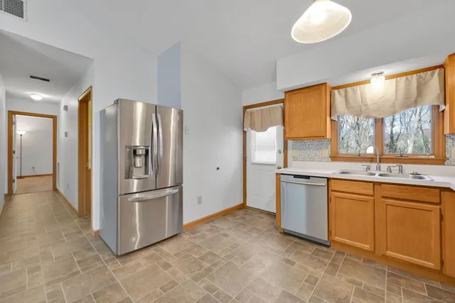 a kitchen with stainless steel appliances granite countertop a refrigerator and a sink