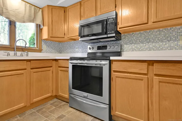 a kitchen with granite countertop cabinets stainless steel appliances and a window