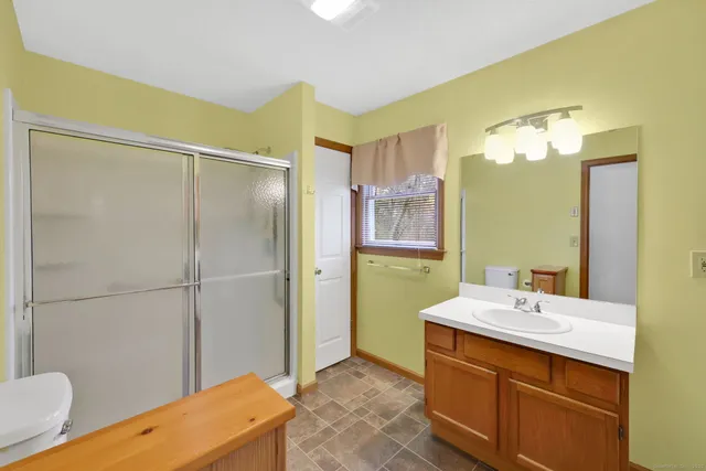 a bathroom with a sink mirror and a shower