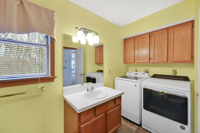 a utility room with cabinets washer and dryer