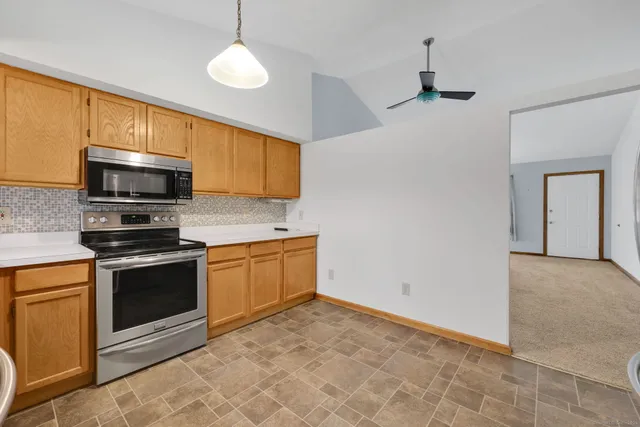 a kitchen with stainless steel appliances granite countertop a stove a sink and a microwave