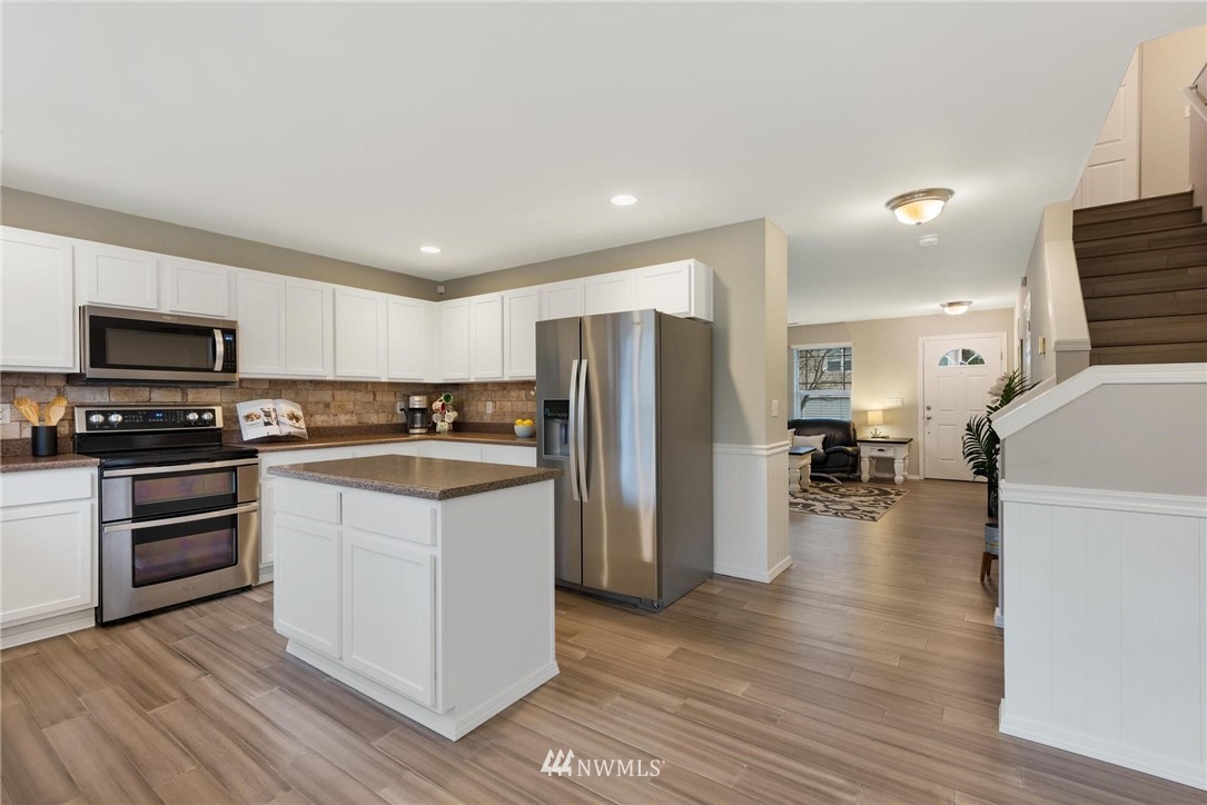 15429 38th Drive Southeast Bothell, WA 98012 - Photo 6 of 26 a kitchen with a refrigerator a stove top oven a sink dishwasher and wooden floor