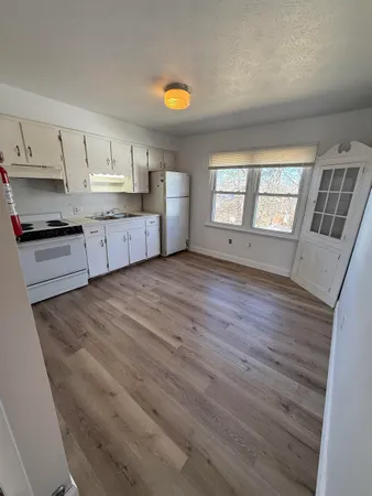 a large kitchen with stainless steel appliances wooden floors and view living room