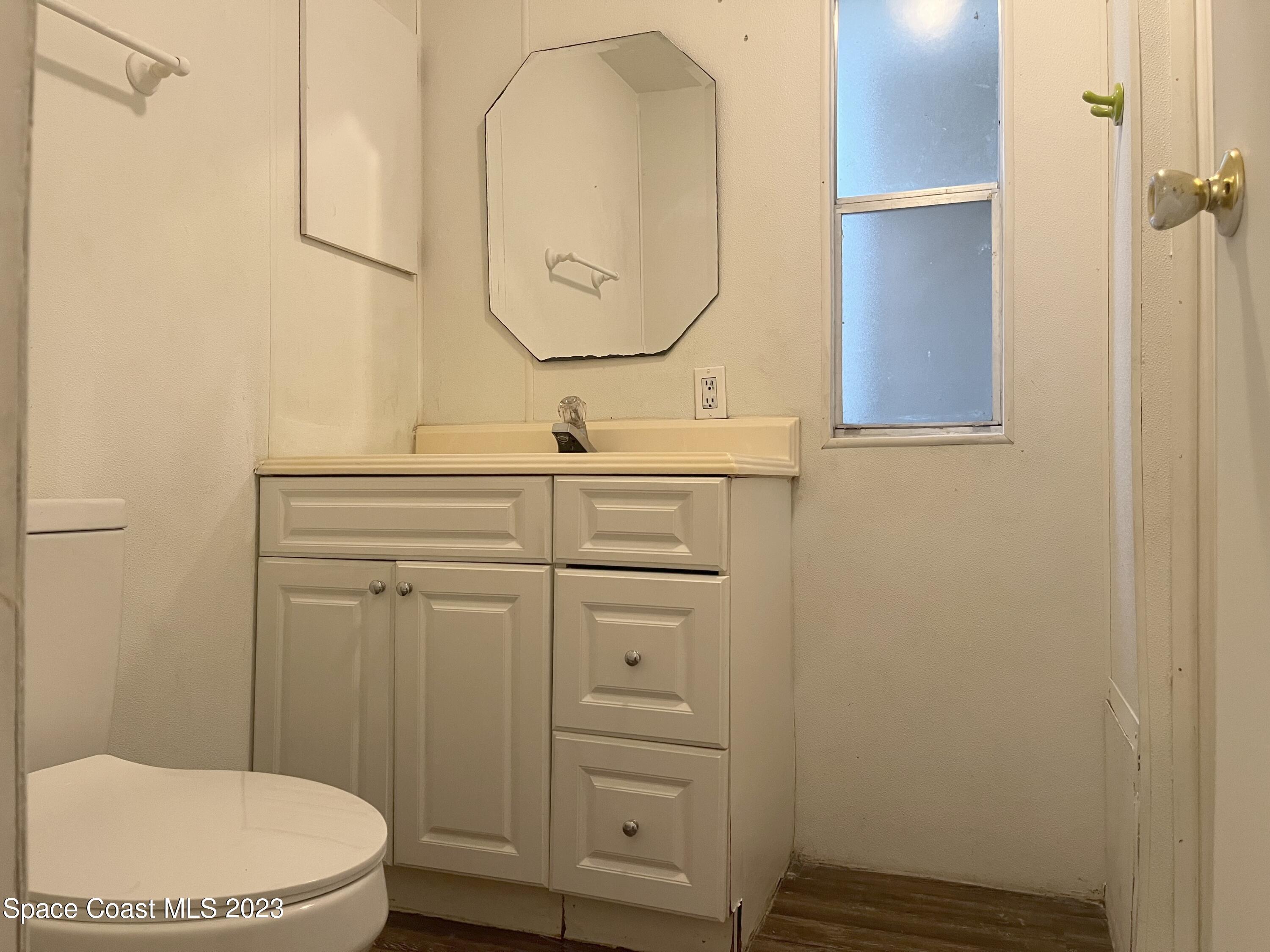 421 Cross Road Cocoa, FL 32926 - Photo 11 of 18 a bathroom with a toilet a sink and mirror