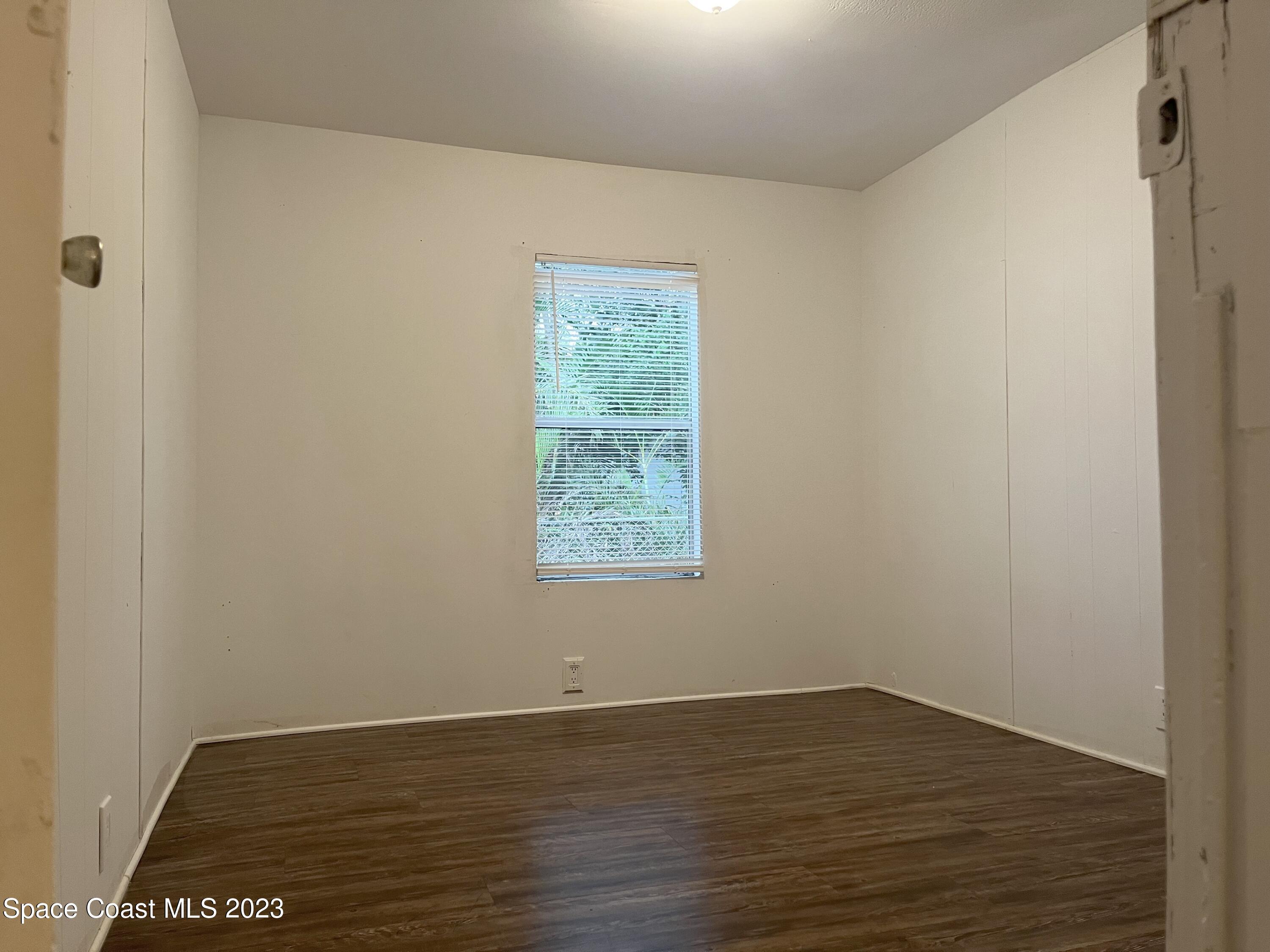 421 Cross Road Cocoa, FL 32926 - Photo 13 of 18 a view of an empty room with wooden floor and a window