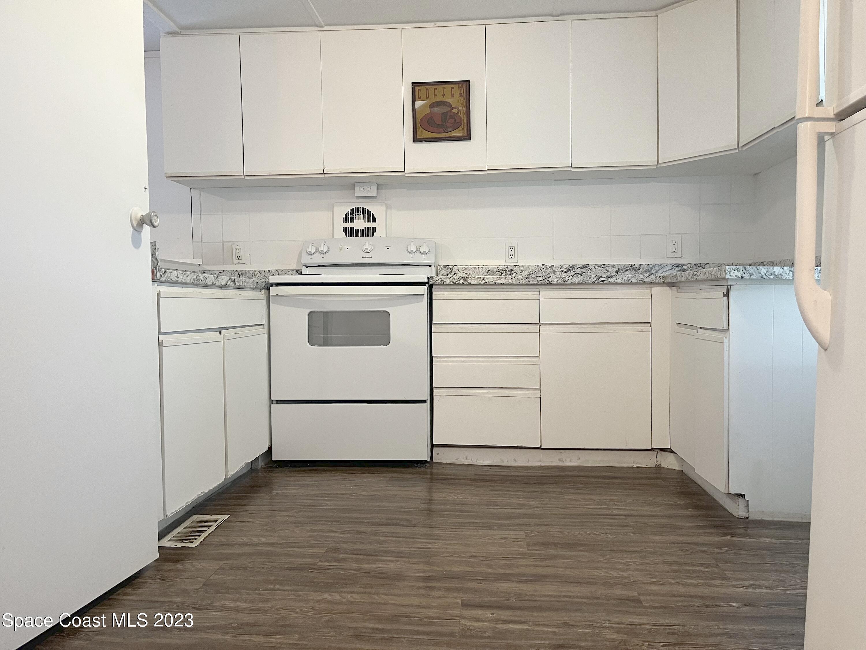 421 Cross Road Cocoa, FL 32926 - Photo 3 of 18 a kitchen with granite countertop white cabinets and white appliances