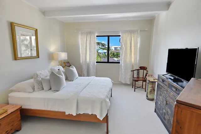 a living room with stainless steel appliances furniture a large window and a kitchen view