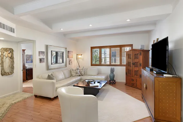 a large white kitchen with a refrigerator a stove a dining table and chairs