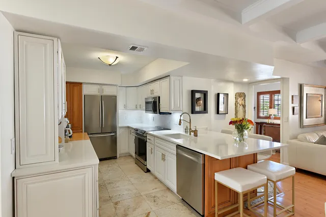 a kitchen with stainless steel appliances granite countertop a sink and a refrigerator