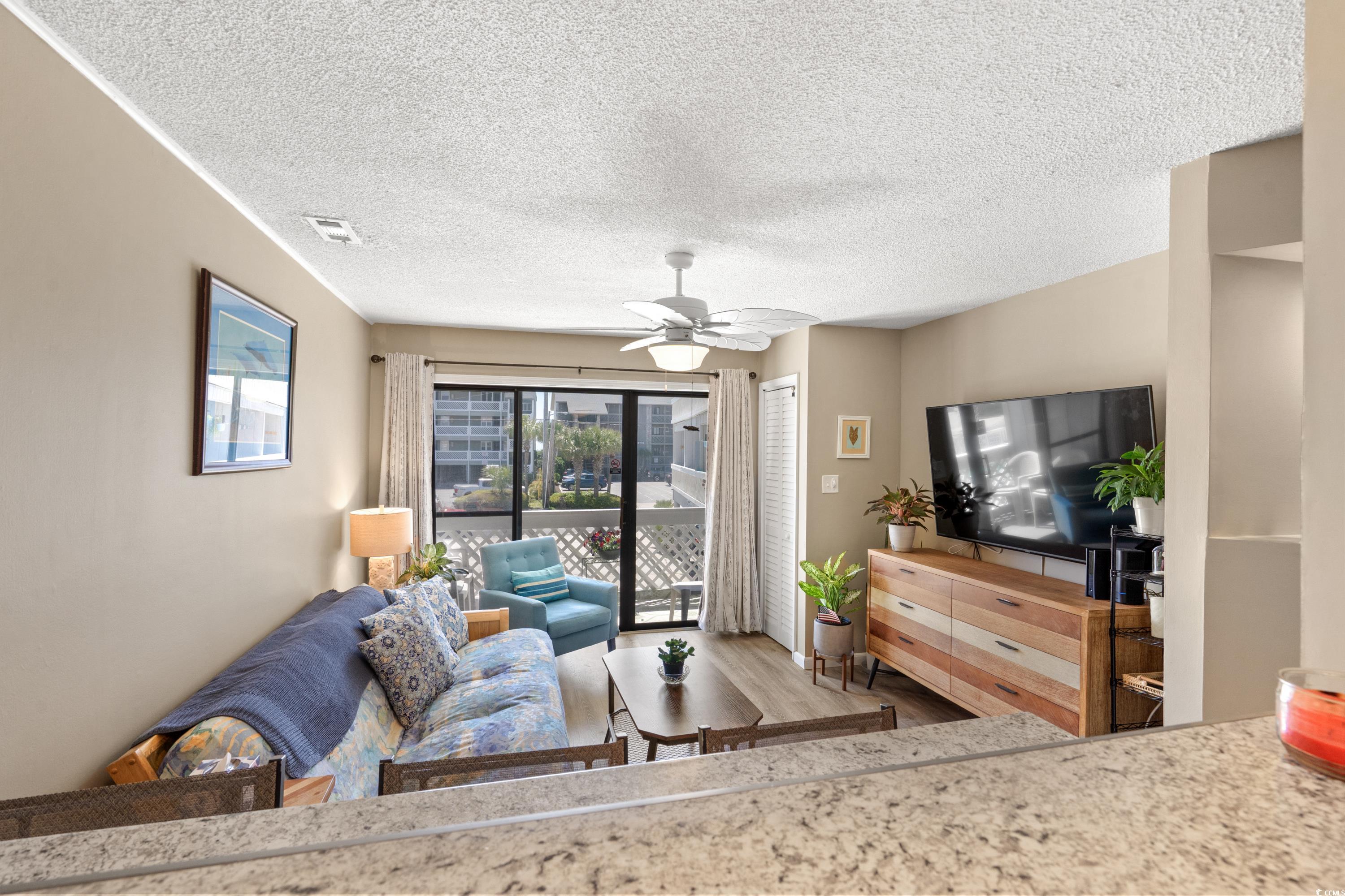 625 North Waccamaw Drive, Unit 107 Murrells Inlet, SC 29576 - Photo 11 of 37 Living area with wood finished floors, a textured ceiling, and a ceiling fan