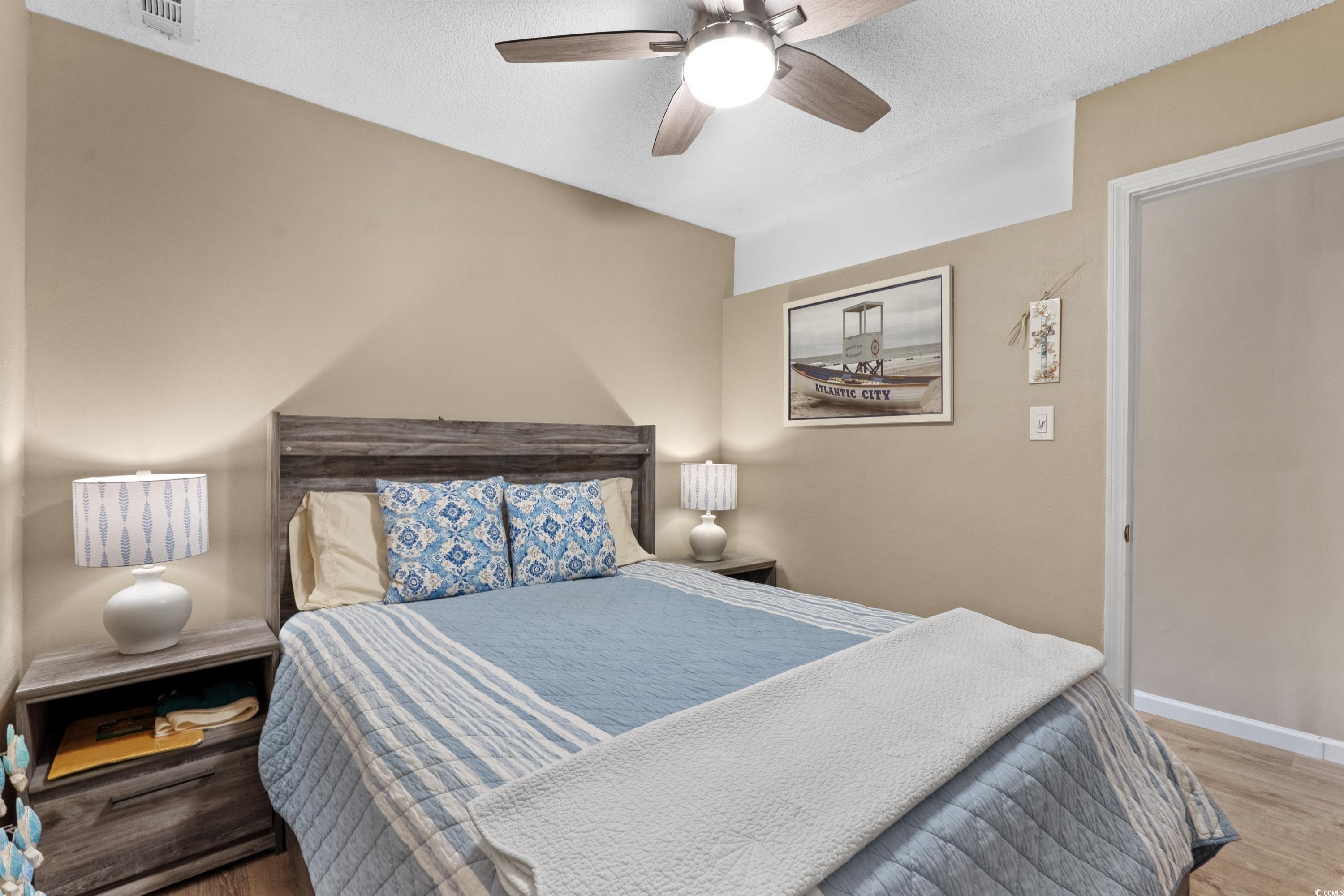 625 North Waccamaw Drive, Unit 107 Murrells Inlet, SC 29576 - Photo 18 of 37 Bedroom featuring wood finished floors, ceiling fan, and baseboards
