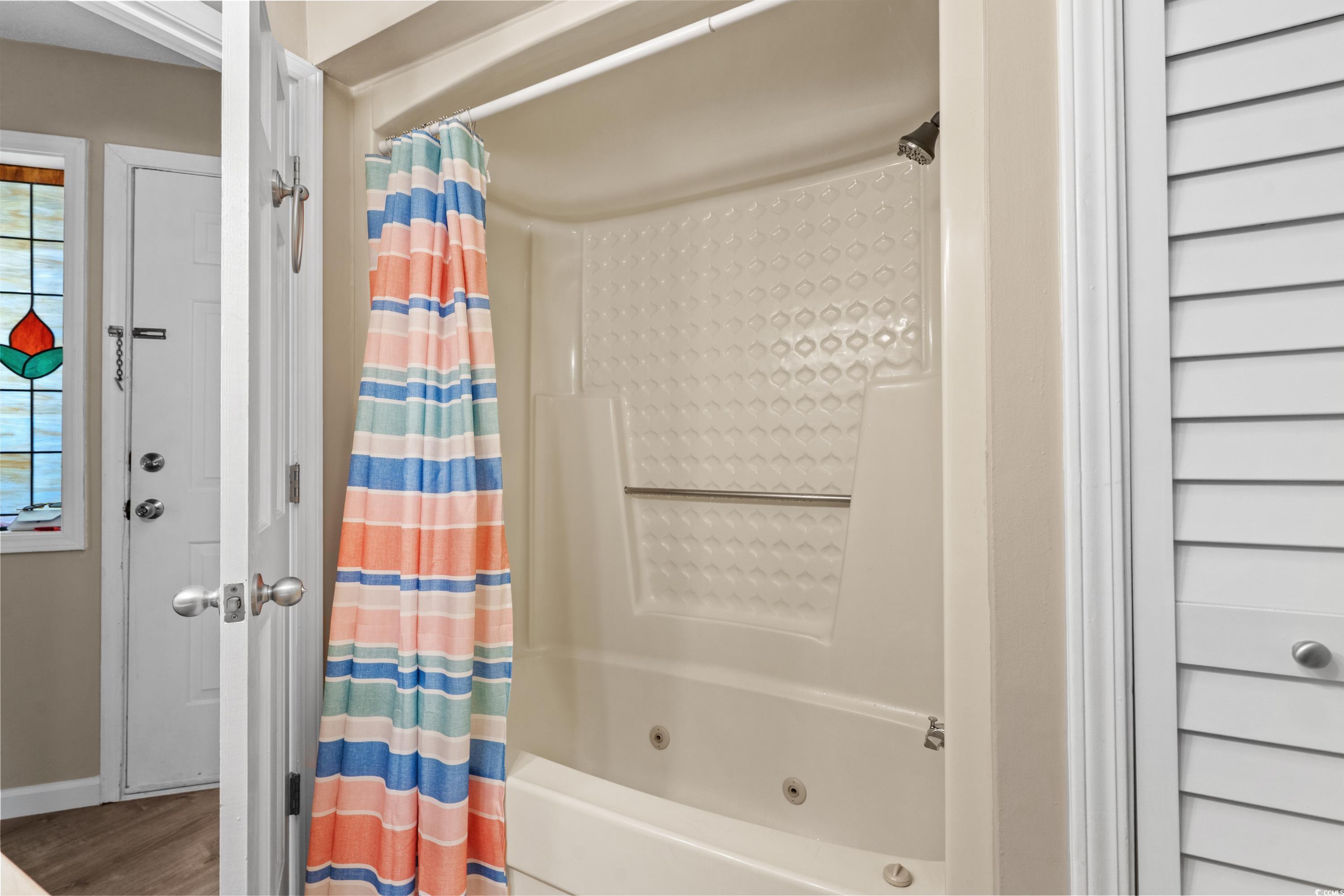 625 North Waccamaw Drive, Unit 107 Murrells Inlet, SC 29576 - Photo 20 of 37 Bathroom featuring a combined bath / shower with jetted tub, baseboards, and wood finished floors