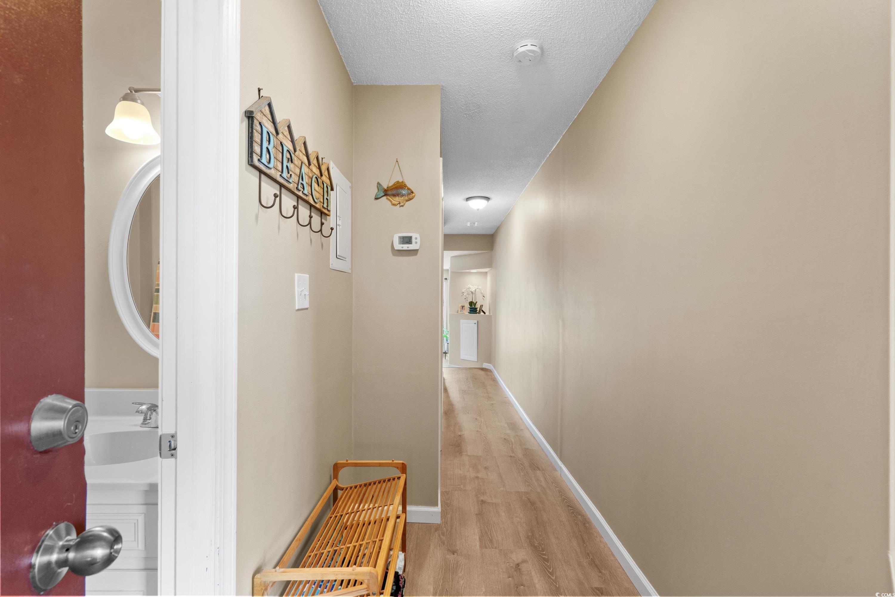 625 North Waccamaw Drive, Unit 107 Murrells Inlet, SC 29576 - Photo 21 of 37 Hall with light wood-style floors, baseboards, and a textured ceiling