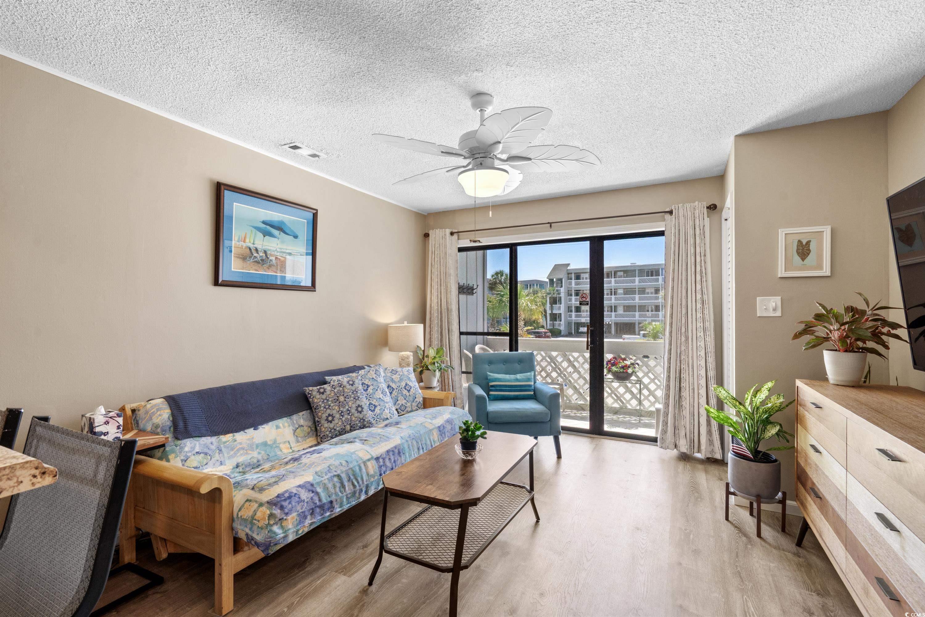 625 North Waccamaw Drive, Unit 107 Murrells Inlet, SC 29576 - Photo 5 of 37 Living area featuring light wood-style flooring, a textured ceiling, and a ceiling fan