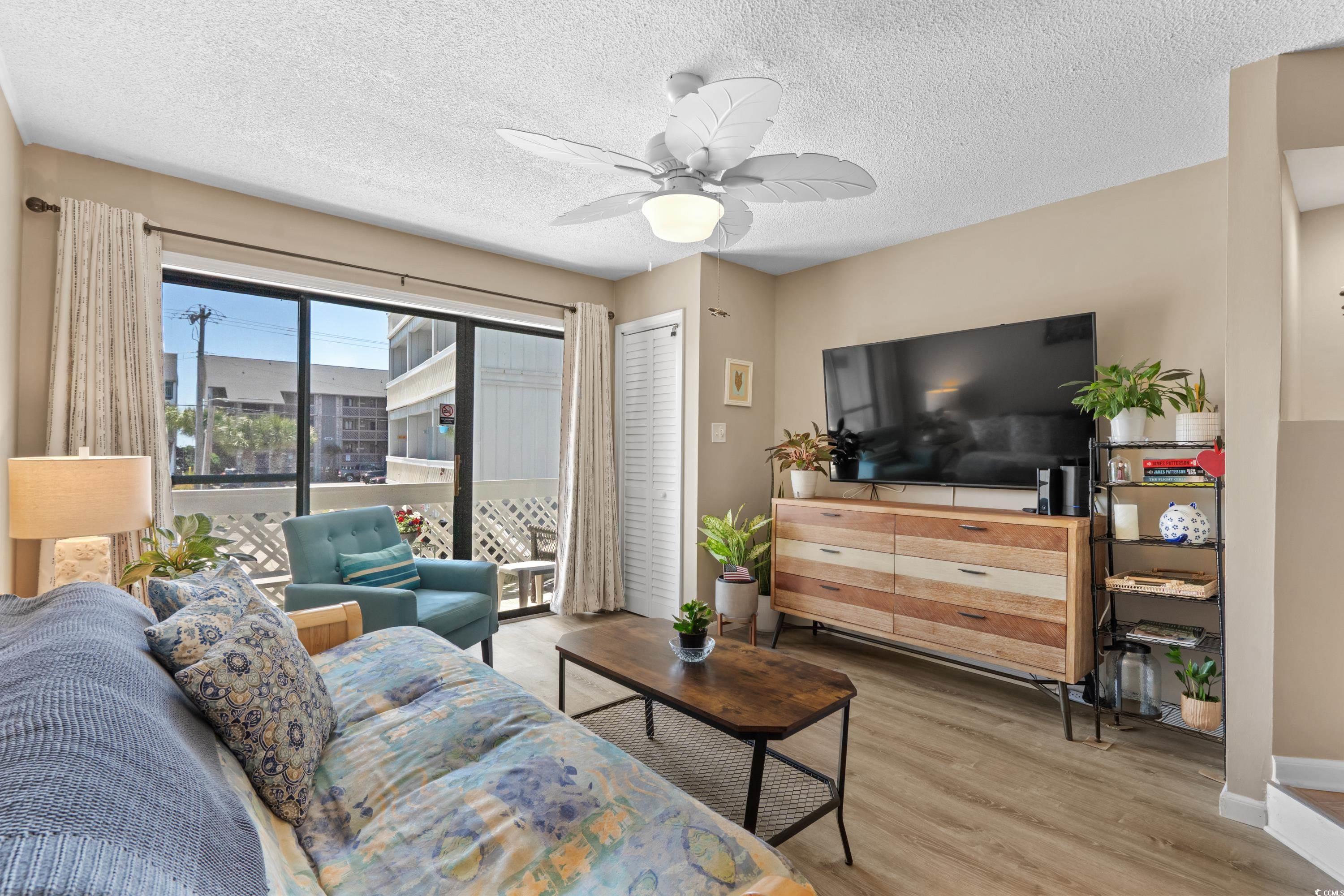 625 North Waccamaw Drive, Unit 107 Murrells Inlet, SC 29576 - Photo 6 of 37 Living area featuring wood finished floors, a ceiling fan, baseboards, and a textured ceiling