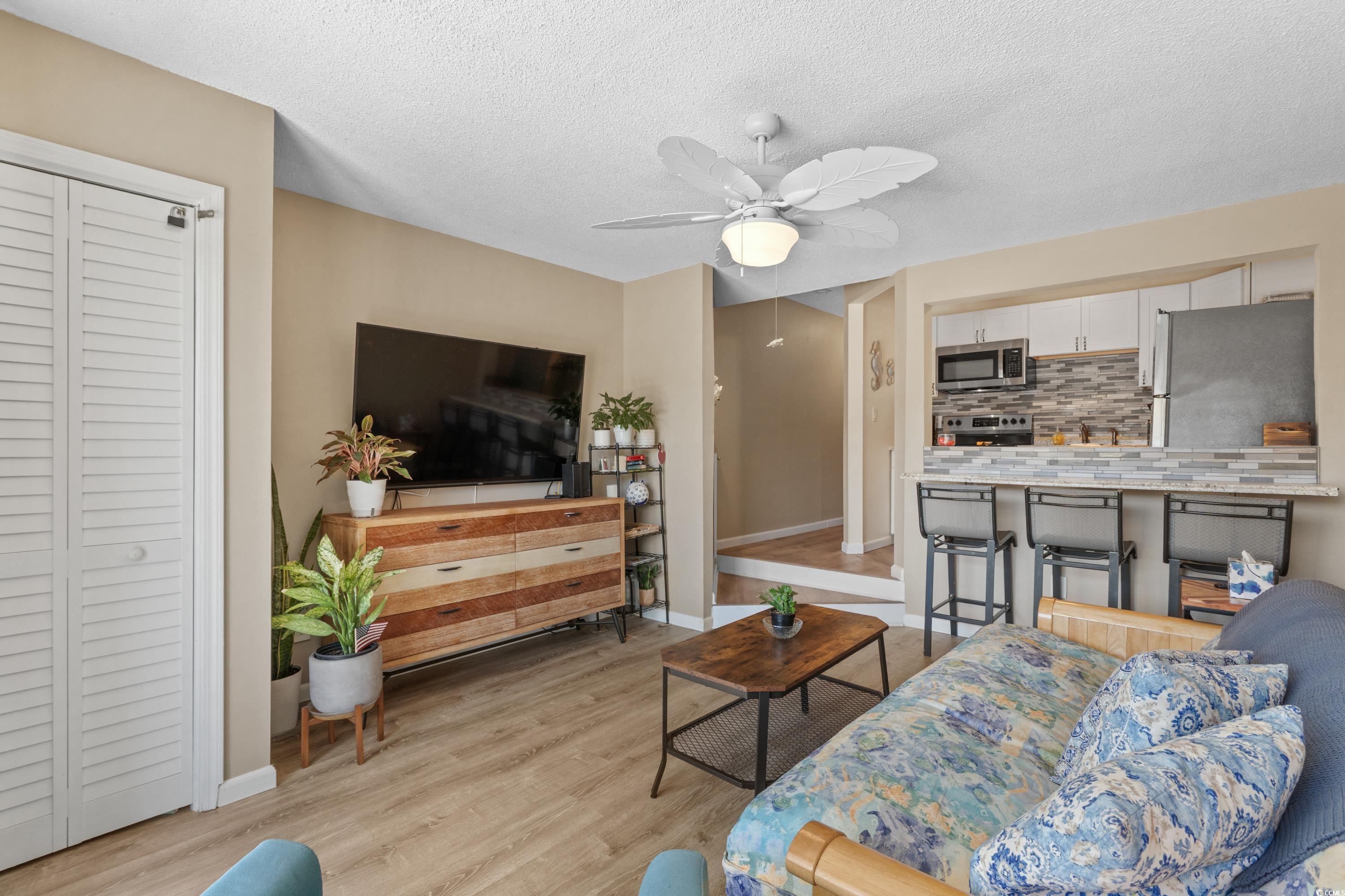625 North Waccamaw Drive, Unit 107 Murrells Inlet, SC 29576 - Photo 7 of 37 Living area with baseboards, light wood finished floors, ceiling fan, and a textured ceiling