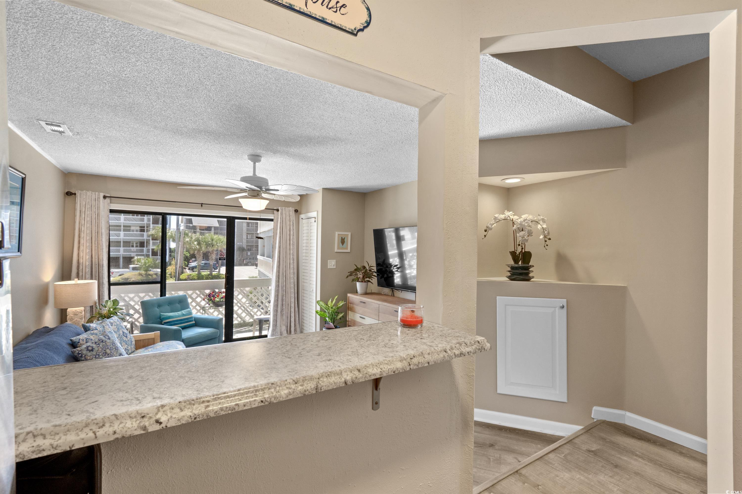 625 North Waccamaw Drive, Unit 107 Murrells Inlet, SC 29576 - Photo 37 of 37 Kitchen featuring light wood-type flooring, a ceiling fan, open floor plan, baseboards, and a textured ceiling