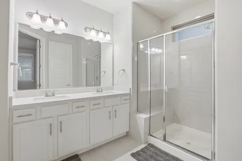 a bathroom with a shower sink and mirror