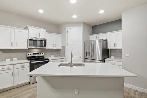 a kitchen with stainless steel appliances a stove sink and microwave