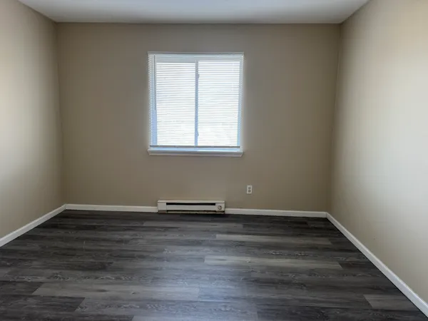 a view of a room with wooden floor and a window