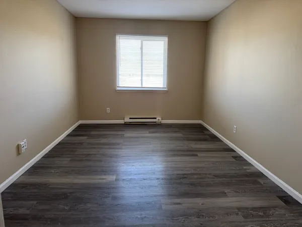 wooden floor in an empty room with a window