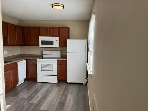 a kitchen with white cabinets and white appliances
