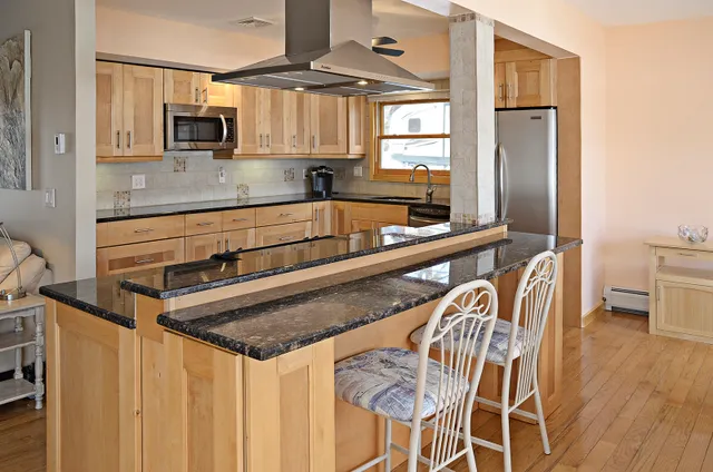 a kitchen with stainless steel appliances granite countertop a sink a microwave cabinets and a refrigerator