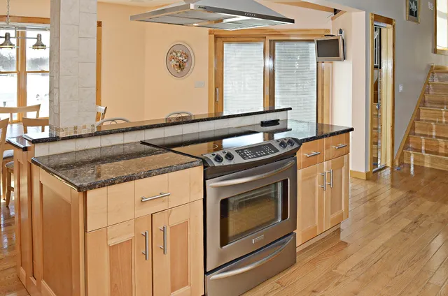 a kitchen with stainless steel appliances granite countertop a stove and a microwave