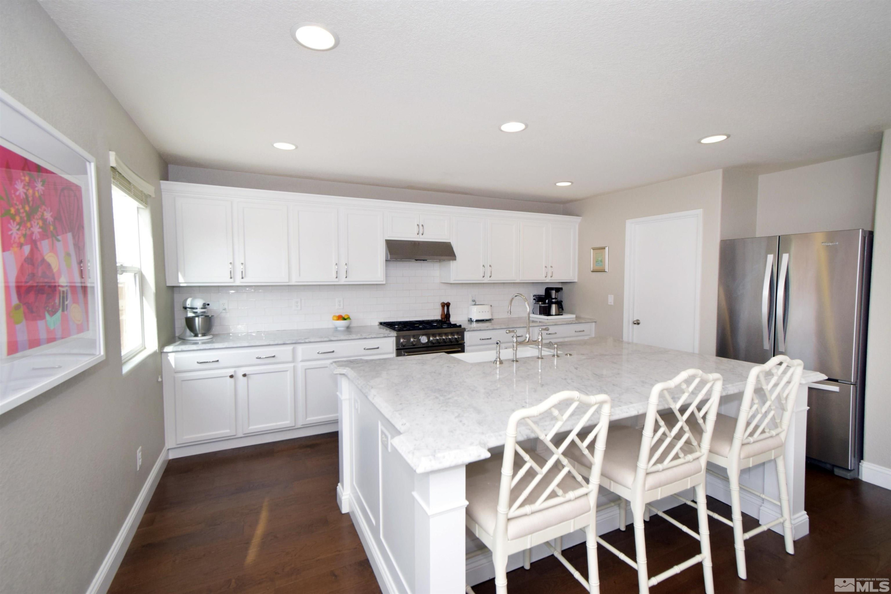 11635 Verazae Drive Reno, NV 89521 - Photo 8 of 27 a large kitchen with kitchen island granite countertop lots of white cabinets appliances and furniture