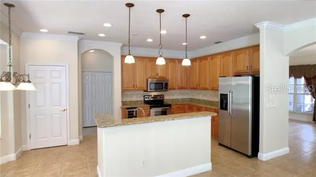 a kitchen with stainless steel appliances granite countertop a refrigerator a oven and a sink