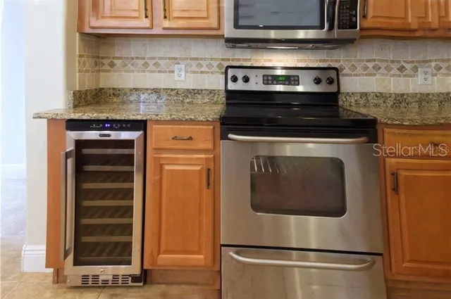 a stove top oven sitting inside of a kitchen and stainless steel appliances