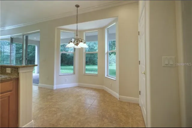 a view of a big room with windows and chandelier