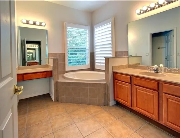 a bathroom with a tub sink and mirror