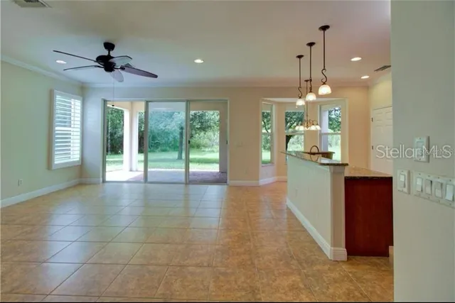 a view of an empty room and kitchen